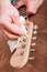 Guitar master polishing headstock of electric guitar, cleaning tuners
