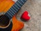 The guitar and red heart on wooden texture background. Love, Mus