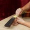 Guitar repair and service - Worker polishing guitar neck frets a