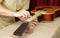 Guitar repair and service - Worker polishing guitar neck frets acoustic guitar sandpaper