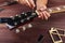 Guitar repairman adjusts the trussrod on electric guitar at workplace