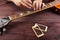 Guitar repairman measures the relief of neck on electric guitar at workplace