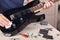 Guitar repairman wipes surface of modern electric guitar with rag