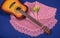 Guitar, shawl and bouquet of flowers on blue background