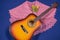 Guitar and shawl decorated with flowers on blue background