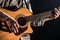 Guitarist, music. A young man plays an acoustic guitar on a black isolated background