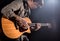 Guitarist, music. A young man plays an acoustic guitar on a black isolated background