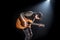 Guitarist, music. A young man plays an acoustic guitar on a black isolated background