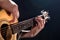 Guitarist, music. A young man plays an acoustic guitar on a black isolated background