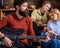 Guitarist playing at birthday, celebration concept. Bearded man performing guitar solo. Man with stylish beard