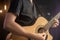 The guitarist plays an acoustic guitar in concert with a pick on a black blurred background