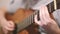 The guitarist plays an acoustic guitar. Guitarist hand and fretboard closeup