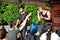 Guitarist and tattooed singer stand in front of group of teenagers.