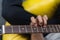 The guitarists fingers are on the neck of the guitar. View from above. Selective focus with blurred background