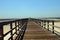 Gulf view of a public pier stretching towards a cloudless blue sky