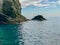 Gulls sit on an rock outcropping under a dramatic cliff over the