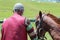 Gulmarg, Jammu and Kashmir- June 17 2019 : A Pony owner with his pony. Preparing for a ride