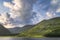 Gummeenduff lake and MacGillycuddys Reeks mountains illuminated by sunset light in Black Valley