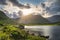 Gummeenduff lake and rocky hills of MacGillycuddys Reeks mountains illuminated by sunlight in Black Valley