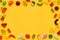 Gummy candy frame border, assorted jelly gum fruit candy sweets on yellow background