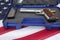 gun or pistol inlaid with wood and gold and bullet holder in a blue box on a american flag background. weapon concept. protection