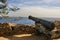 A gun on the wall of an old fortress over the sea