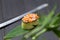 Gunkan Sake Green sushi with salmon and black tobiko caviar served in cucumber on bamboo leaf near Japanese knife.