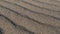 Gusty wind blowing sand over sand dune close-up, slow motion