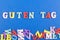 GUTEN TAG GOOD DAY word on blue background composed from colorful abc alphabet block wooden letters, copy space for ad