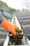 Gutter Leaf Removal Photo. Roof gutter with fallen leaves. Rain gutter with roofer hand cleaning photo