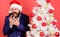 Guy annoyed by quality of mobile connection holiday day. Mobile tariff roaming. Man bearded face wear suit and santa hat