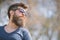 Guy with beard wears sunglasses. Hipster with beard and mustache on strict face, nature background, defocused. Man with