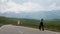 Guy in black clothes runs with a skateboard on the road