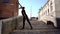 Guy in black dances on historical stone stairs of old city