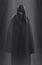 A guy in a black robe standing in the dark