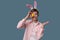 Guy with bunny ears with colorful Easter eggs in his hand in pink shirt.