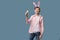 Guy with bunny ears with colorful Easter eggs in his hand in pink shirt.