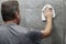 Guy Cleaning a Gray Tile Bathroom Shower Wall with a Rag