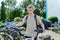 Guy college student with backpack with bike, educational building background