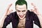 Guy with crazy joker face, green hair and idiotic smike. carnaval costume