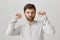 Guy dances while standing in subway, being careless about crowd. Portrait of pleased young man with beard moving