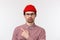 Guy disapprove boring party, express dislike. Skeptical cute caucasian male in red beanie and glasses, sulking frowning