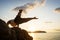 Guy doing acrobatic yoga at sunset by the sea