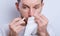 Guy dripping nasal drops in nose, portrait