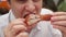 Guy eats fried chicken in a fast food restaurant closeup