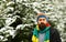 Guy with fir trees covered with snow on background, defocused.