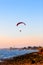 Guy flying on the clearly blue sky and wonderful beach by paramotor