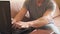 Guy a freelancer working on laptop at home. Man hands typing on notebook keyboard.