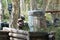 A guy during a game of paintball on the landfill. Camouflage suit, protective mask and weapons. Tires, barrels, wooden fences in t