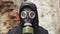 Guy in gas mask among debris in an abandoned building. Post apocalyptic world Stalker concept, survivor after nuclear chemical war